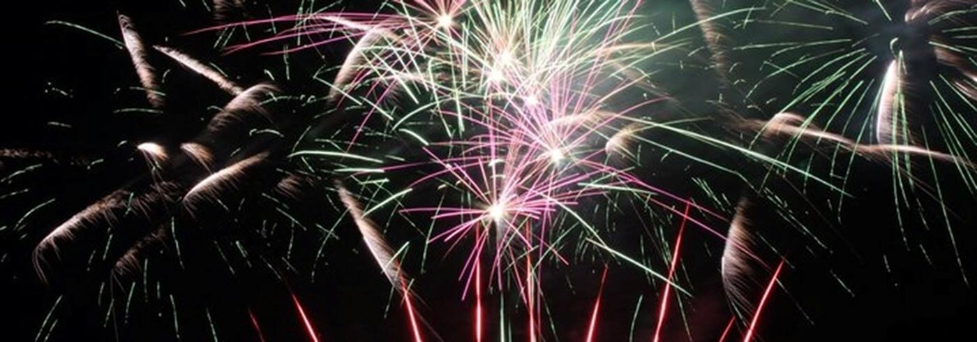 Firework display in white, pink and green.
