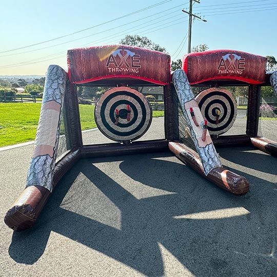 A dual lane inflatable axe throwing set up for a party.